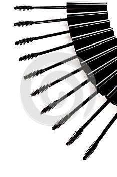 A lot of black Mascara wands on white background