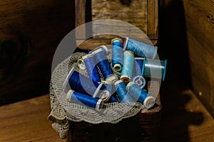 Lot of blue threads on a cloth in a wooden box