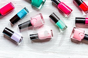 Lot of bottles nail polish on wooden background top view