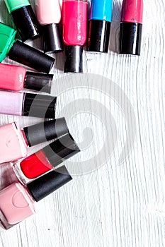 Lot of bottles nail polish on wooden background top view