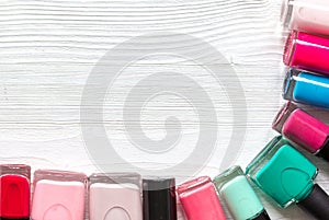 Lot of bottles nail polish on wooden background top view