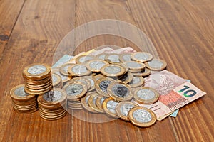 Lot of brazilian coins and bank notes on a wood table