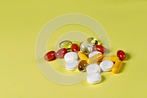 A lot of bright medicine pills on a yellow background.