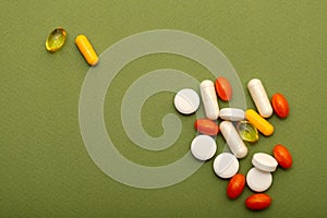 A lot of bright pills of drugs on a green background.