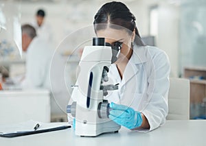 A lot can be deduced from a little. a young scientist using a microscope in a lab.