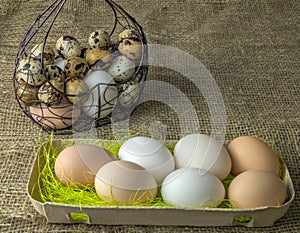 A lot of chicken eggs and quail eggs lies of a metal structure in the shape of a heart and an ear lying on the wooden table