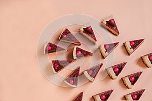 lot of chocolate cake slices on pink background. Minimal composition of tart pieces. sweet dessert