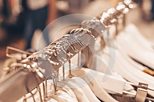 A lot of clothes hangers on the rack in the shop. Concept of shopping and fashion.