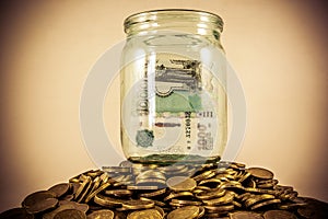 A lot of coins and a glass jar photo