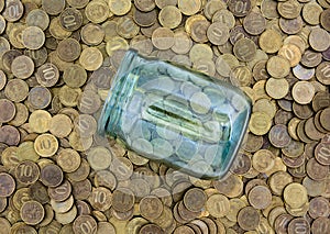 A lot of coins and a glass jar