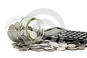 A lot of coins in a glass jar and coins with calculator, money investment, saving money