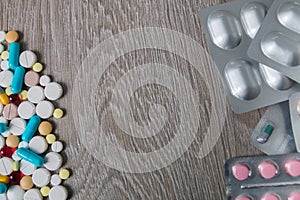 Lot of colorful medication and pills from above on grey wooden background. Copy space. Top view, frame. Painkillers, tablets, gene