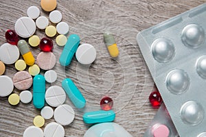 Lot of colorful medication and pills from above on grey wooden background. Copy space. Top view, frame. Painkillers, tablets, gene