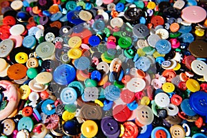 Lot of colorful plastic clothing buttons. Many small round vintage buttons pattern background