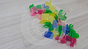 A lot of colorful small holding clips placed on a wooden floor