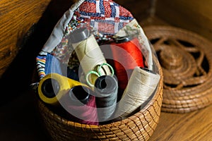 Lot of colorful yarn rolls in a woven basket in a tailor's studio