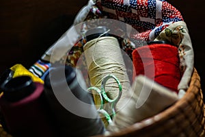 Lot of colorful yarn rolls in a woven basket in a tailor's studio