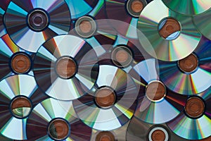 A lot of computer cd disks reflecting on a wooden surface, background, texture