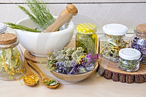 Lot of different dry herbal remedy plants in glass jars.