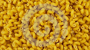 A lot of dry pasta as spirals, rotate circle. Popular Italian and European cuisine. Food background.