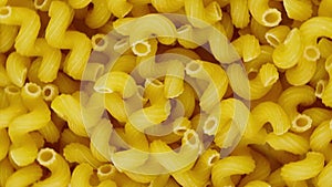 A lot of dry pasta as spirals, rotate circle. Popular Italian and European cuisine. Food background. Top view. Top down