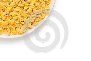 a lot of dry unprepared pasta - cockerels on a beige plate on a white background, copy space