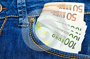 A lot of euro money in a pocket of jeans trousers