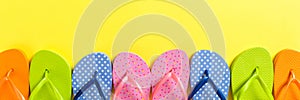 A lot of flip flop colored sandals, summer vacation on colored background, banner copy space top view