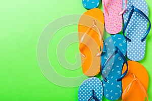 A lot of flip flop colored sandals, summer vacation on colored background, copy space top view