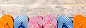 A lot of flip flop colored sandals, summer vacation on wooden background, banner copy space top view