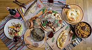 A lot of food on the wooden table. Georgian cuisine. Top view. Flat lay . Khinkali and Georgian dishes