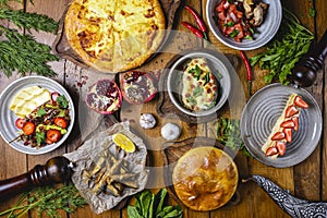 A lot of food on the wooden table. Georgian cuisine. Top view. Flat lay. Khinkali and Georgian dishes