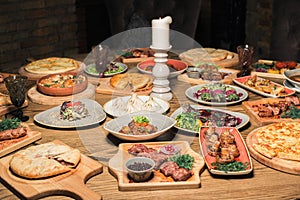 A lot of food on the wooden table. Georgian cuisine. Top view. Flat lay . Khinkali and Georgian dishes