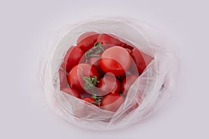 A lot of fresh cherry tomatoes in a package isolated on white background. One is cut in half.