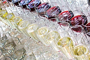 A lot of glasses with white wine and red wine glasses in a row