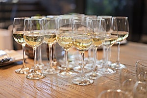 A lot of glasses with white wine in a restaurant at a buffet or banquet