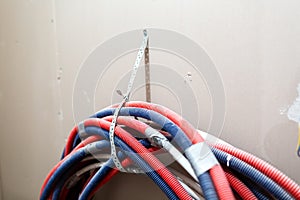 A lot of Internet, Ethernet UTP cables and electrical cables without cable trays are temporary installed on the walls