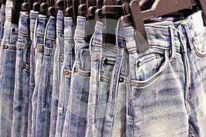 A lot of jeans light blue on hangers in the store