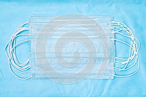 Lot of medical face mask on blue background. Concept quarantine, grippe, pandemic outbreak, hygiene. Antibacterial photo