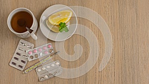 A lot of medication and pills from above on beige background. All for flu, pills, vitamins, capsules, thermometer