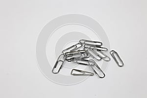 A lot of metal paperclips isolated on a white background, a set of office supplies