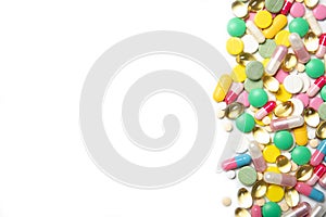 A lot of multi-colored pills on a white background. Dietary supplements.