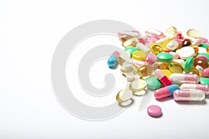 A lot of multi-colored pills on a white background. Dietary supplements.