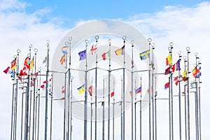 A lot of national flags of european countries on flagpoles abova blue sky