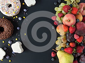 A lot of natural and healthy vitamin fruits, berries vs sweet and junk food on a black background. Vegan eco safe food. The right