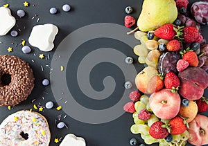 A lot of natural and healthy vitamin fruits, berries vs sweet and junk food on a black background. Vegan eco safe food. The right