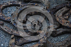 a lot of old rusty horseshoes on a dark photo with blur