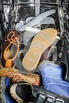 A lot of old shoes loaded in the dishwasher.