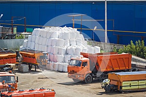 A lot of orange Kamaz trucks stands on the truck parking