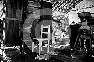 A lot of paraphernalia wardrobe, chairs, machines and other stuff at a shed [Black and White]